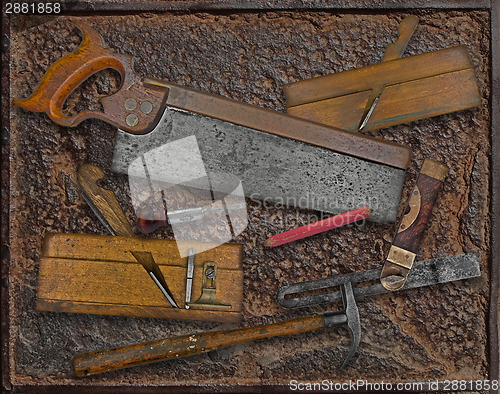 Image of vintage woodworking tools over rusty plate