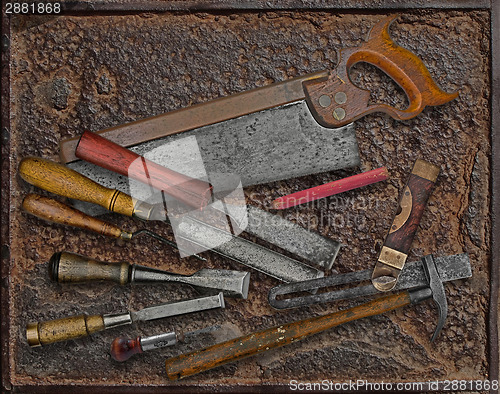 Image of vintage woodworking tools over rusty plate