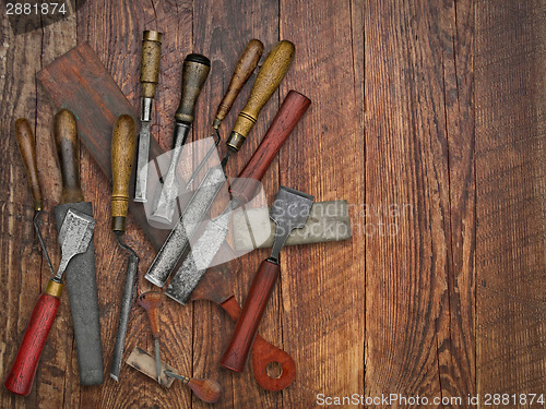 Image of vintage chisels and stones collage over old wooden bench