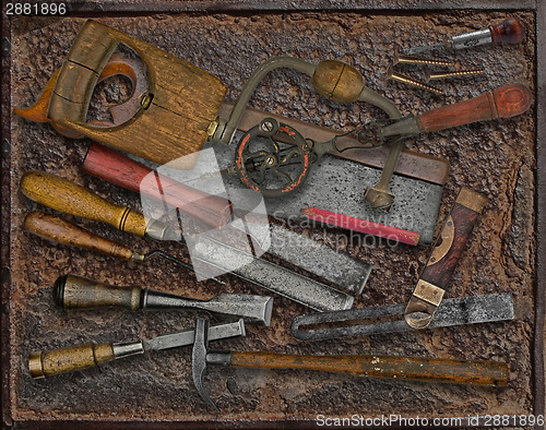 Image of vintage woodworking tools over rusty plate