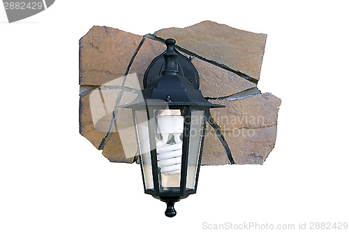 Image of Street light on a fragment of a stone wall.