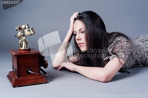 Image of Attractive sad young woman waiting call