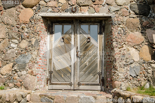 Image of horseshoe hang over stone wall wooden door  