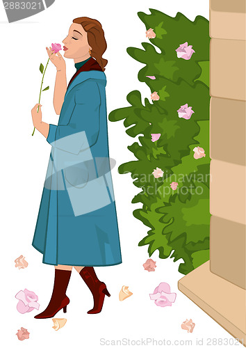 Image of Retro girl with flower near rose bush