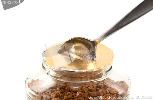 Image of Teaspoon breaking the foil seal on a jar of coffee