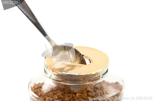 Image of Ripping a hole in the foil of a jar of coffee with a teaspoon