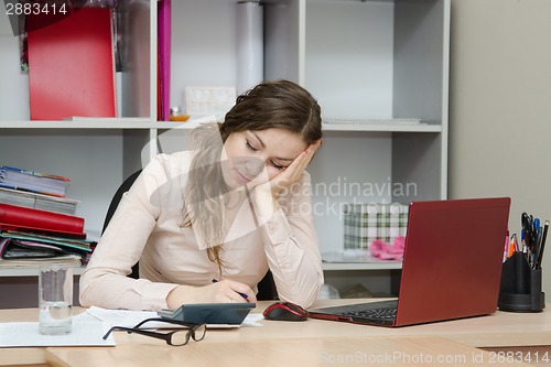 Image of Girl sleeping on a workplace at office
