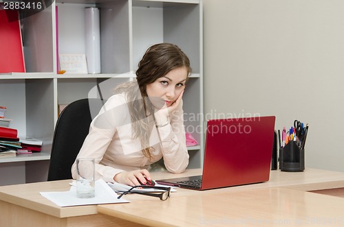Image of Tired girl on a workplace at office