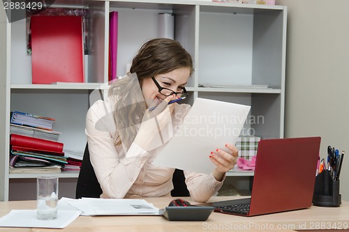 Image of Girl laughs while reading a document in the workplace