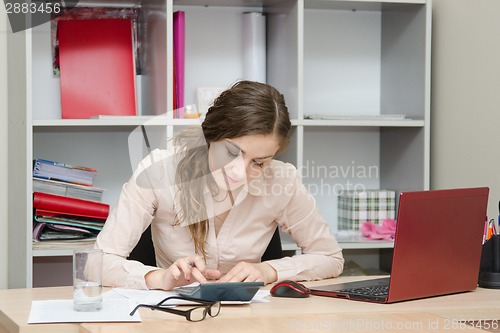 Image of young girl thinks on the calculator