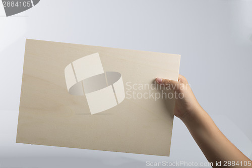 Image of Plywood sign held up by young hands