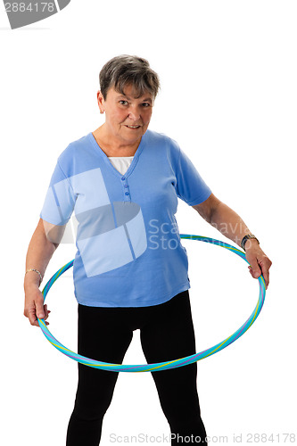 Image of Senior woman exercising with hula-hoop