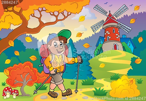 Image of Hiker walking on path near windmill