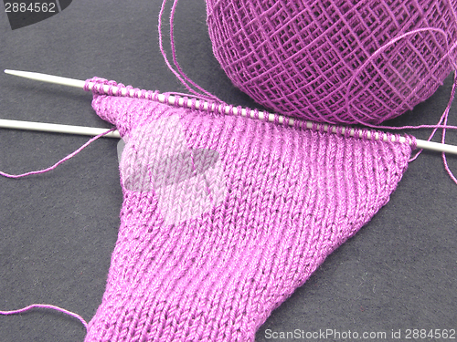 Image of Pink colored knitting on a  black background