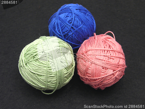 Image of Three balls of wool  on a black background