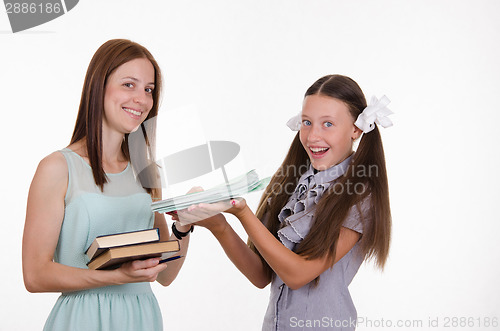 Image of The teacher gives the student notebooks