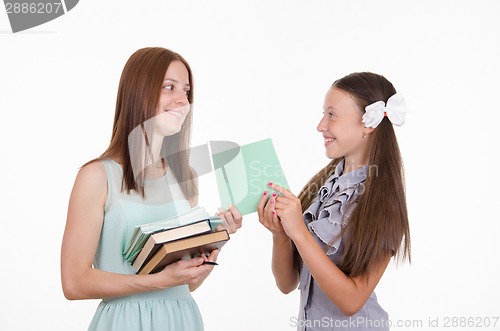 Image of The teacher gives the student a proven notebook