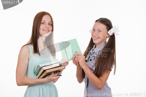 Image of The teacher gives the student a notebook