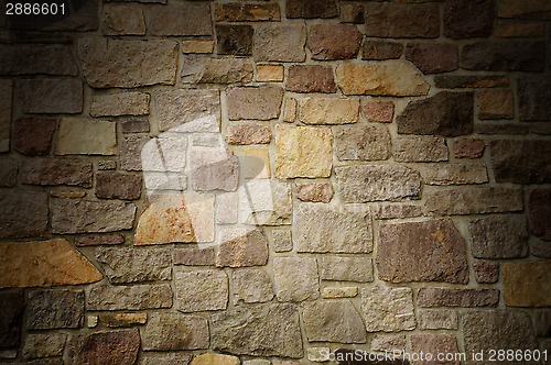 Image of Masonry Wall of Multicolored Stone Lit Dramatically