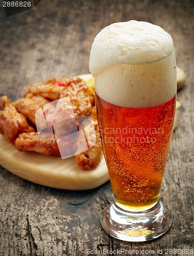 Image of glass of fresh beer and fried chicken wings