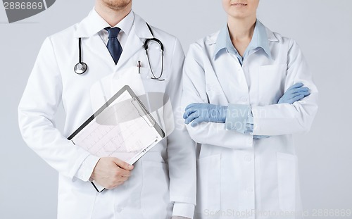 Image of nurse and male doctor holding cardiogram