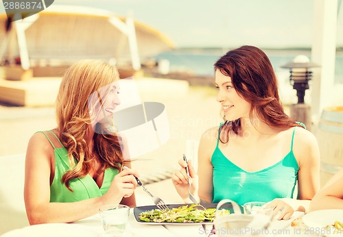 Image of smiling girls in cafe on the beach