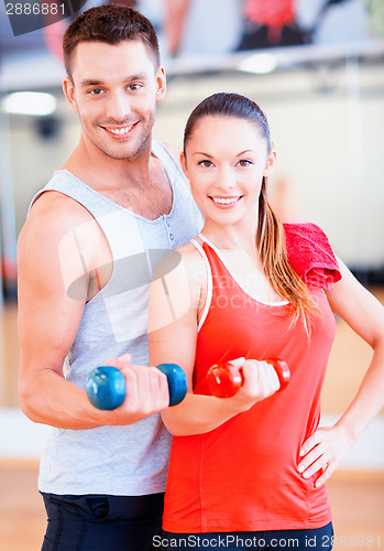 Image of two smiling people working out with dumbbells