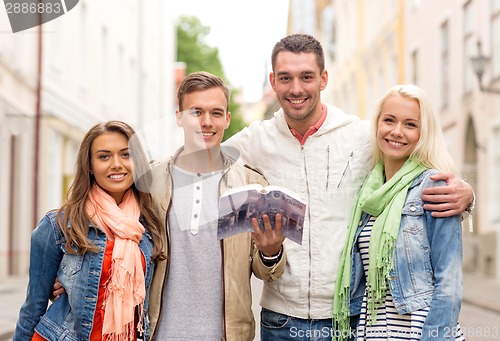 Image of group of friends with city guide exploring town