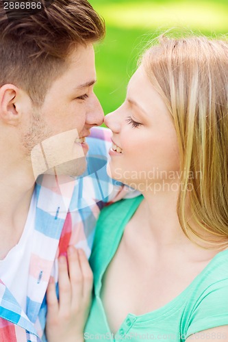 Image of smiling couple touching noses in park