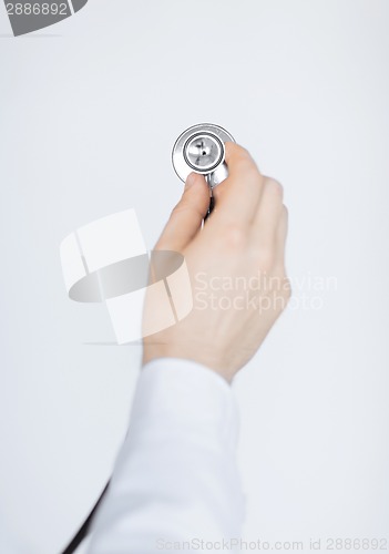 Image of doctor hand with stethoscope listening somebody