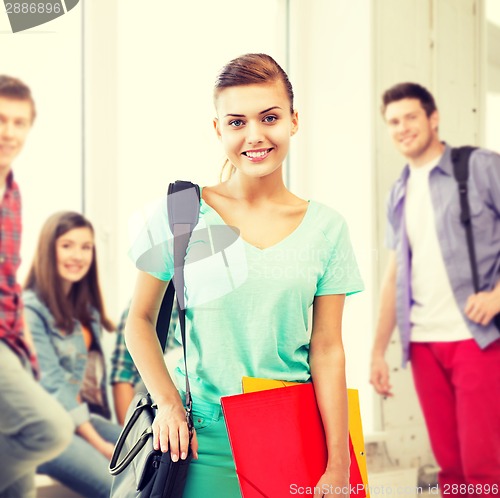 Image of student girl with school bag and color folders