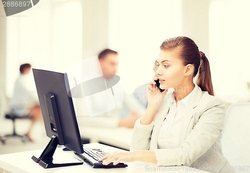 Image of businesswoman with smartphone in office