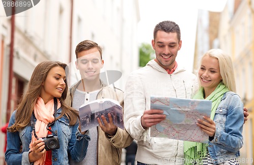 Image of group of friends with city guide, map and camera