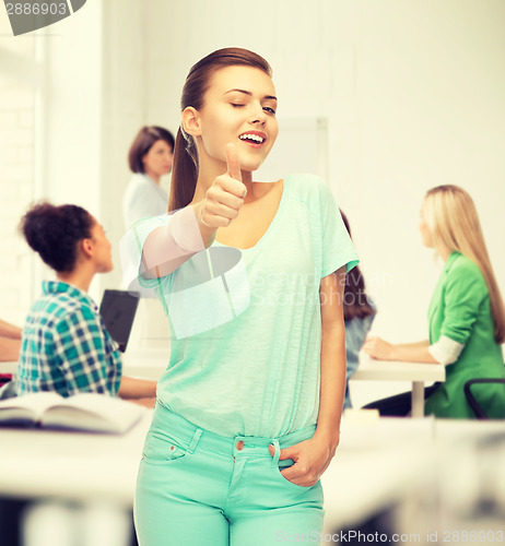 Image of smiling girl in color t-shirt showing thumbs up