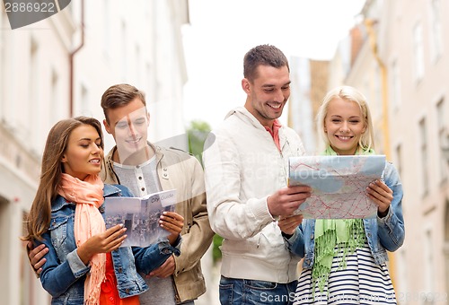 Image of group of smiling friends with city guide and map