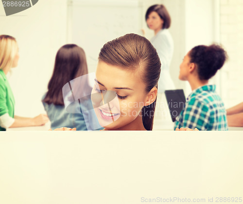 Image of smiling student girl with white blank board