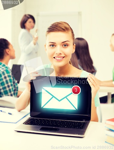 Image of girl holding laptop with email sign at school