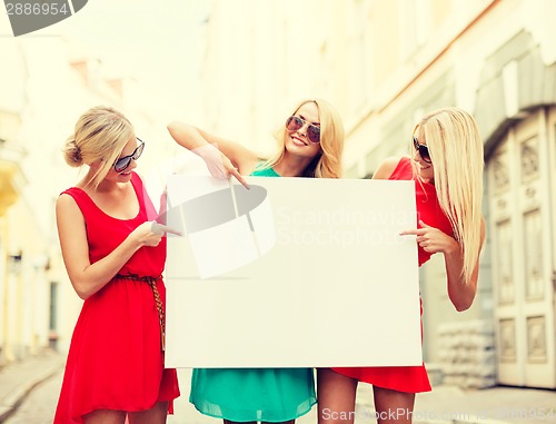 Image of three happy blonde women with blank white board