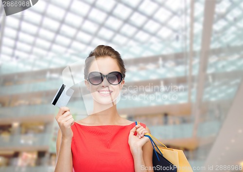 Image of smiling woman with shopping bags and plastic card