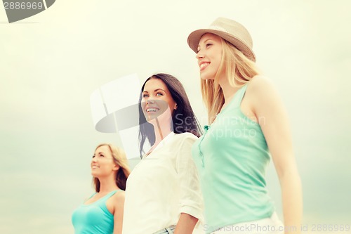 Image of group of smiling girls chilling on the beach