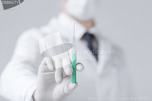 Image of male doctor holding syringe with injection