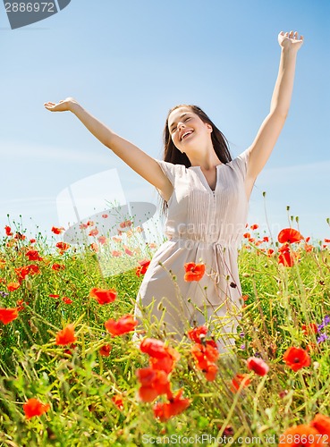 Image of smiling young woman on poppy field