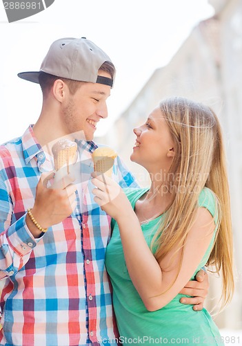 Image of smiling couple with ice-cream in city