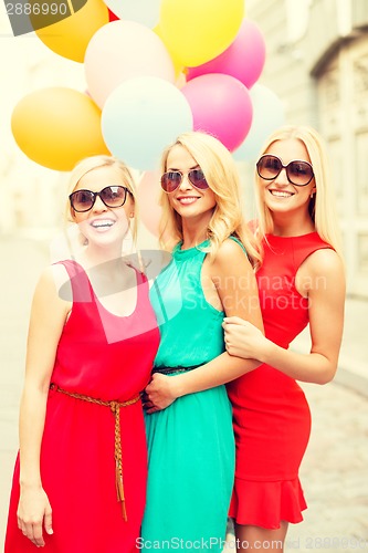 Image of beautiful girls with colorful balloons in the city