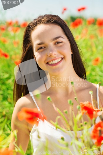 Image of smiling young woman on poppy field