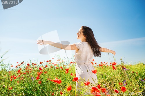 Image of smiling young woman on poppy field