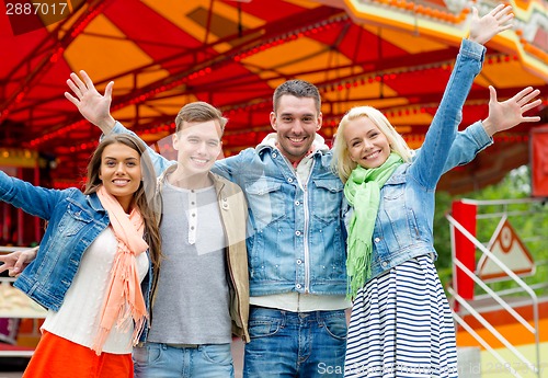 Image of group of smiling friends waving hands