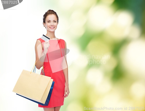 Image of smiling woman with shopping bags and plastic card