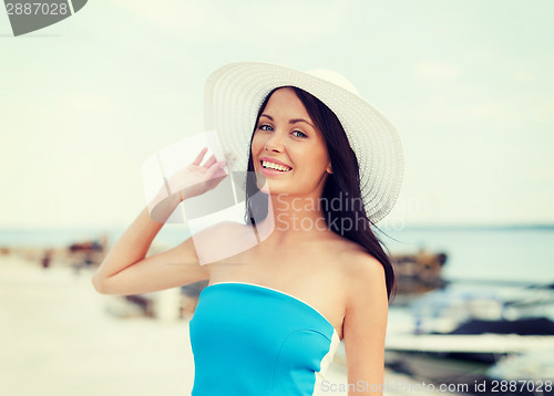 Image of girl in hat standing on the beach