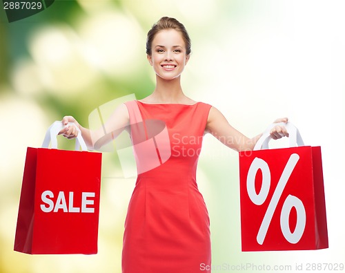 Image of young woman in red dress with shopping bags
